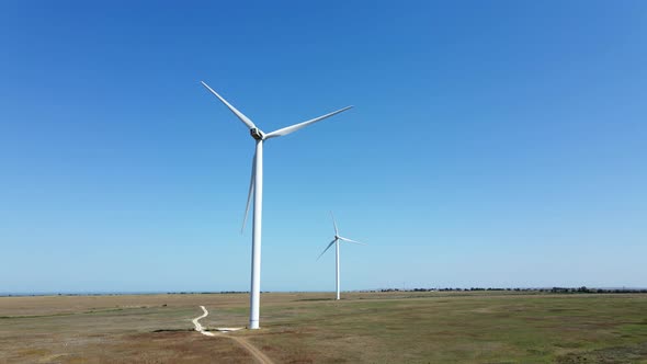 Working Wind Turbines Standing on the Field in Summer