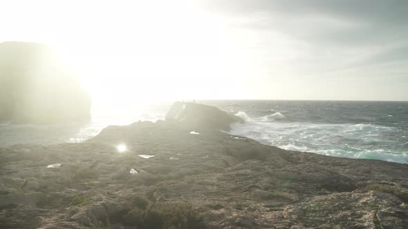 People Shadows Walking on the Top of Fungus Rock Islet - Limestone Lump in the Maltese Archipelago