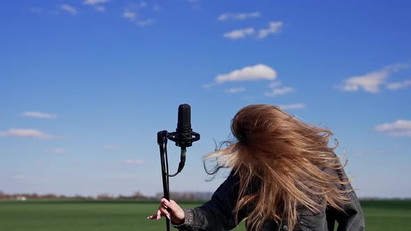 Young girl standing and singing the middle of the fields, enjoying and having fun