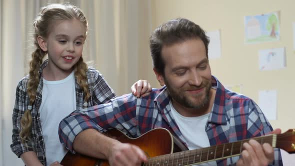 Talented Daughter Singing While Father Playing Guitar, Musical Hobby, Having Fun