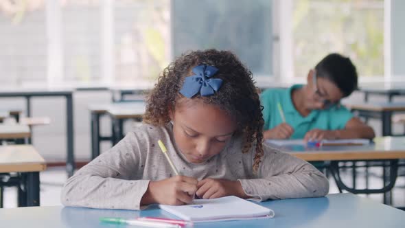 Focused Black Pupil Girl Using Pen