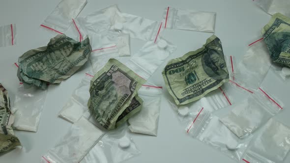 Portions of Cocaine with Pills and Crumpled Money on the Table