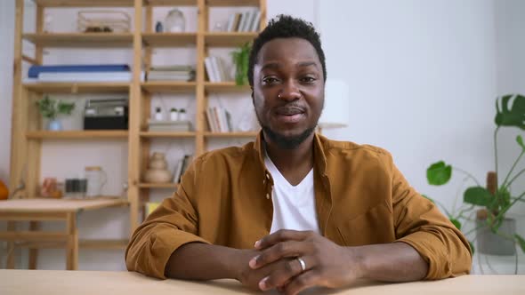 Portrait of Man with African Appearance Talking at Table in Home Interior Spbas