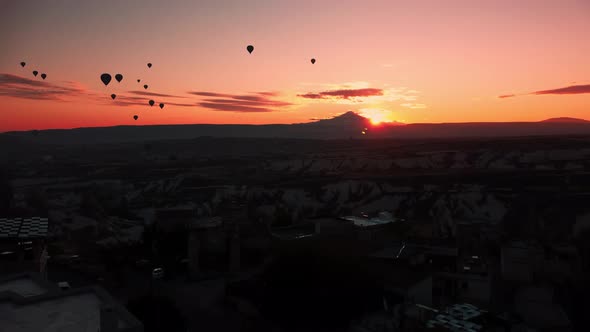 Drone Footage of Sunset Over Cappadocia Limestone Valley and Hot Air Balloons Flying in the Sky