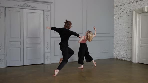 Emotional Contemporary Dance of Young Woman and Man in Rehearsal Hall