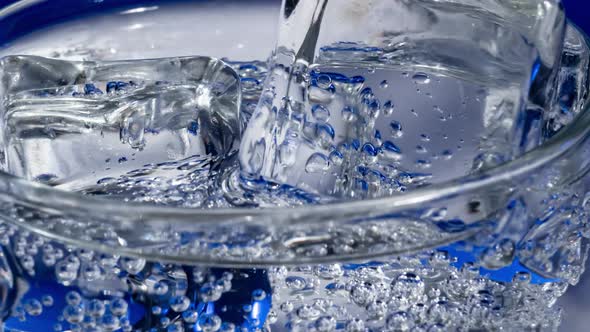 Glass of Water with Ice on a Dark Blue Background