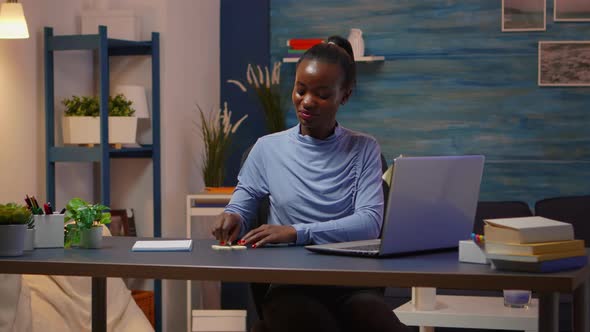 African Smiling Freelancer Typing on Computer and Writing To Do List