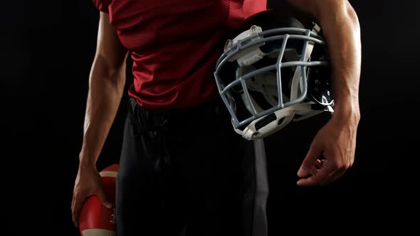 American football player holding a ball and head gear 4k