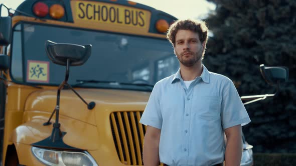 Thoughtful Bus Driver Standing in Front Yellow Vehicle Looking Camera Close Up