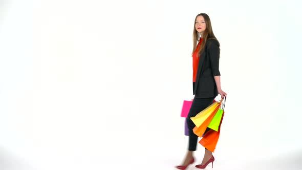 Female Shopper Holding Multicolored Shopping Bags on White Background in Studio