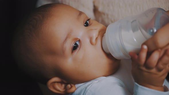 Close Up Dark Skin Baby Drinking His Baby Milk From the Bottle