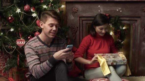 Happy Mixedraced Couple Packing the Presents at Home