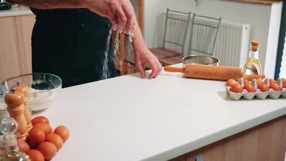 Grandfather Sieving Flour on Wooden Table