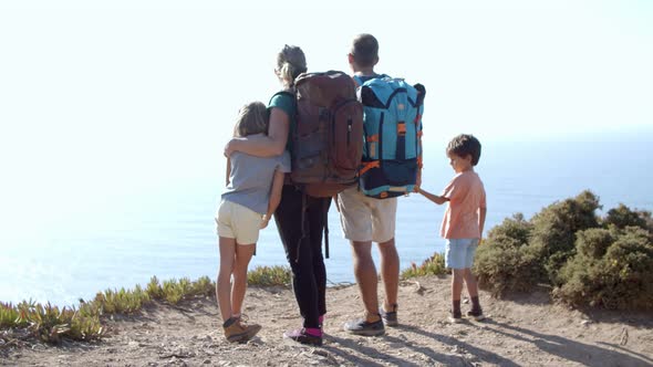 Family of Active Tourists Standing on Footpath at Cliff