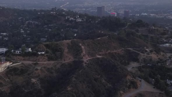 AERIAL: Over Hollywood Hills at Sunrise with View on Hills and the Valley and Power Lines in Los