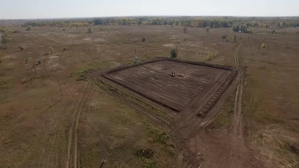 Aerial Shot of Oil Well in Field, Workers Are Inspecting and Servicing