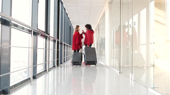 Couple with Suitcases Drinking Coffee at Airport