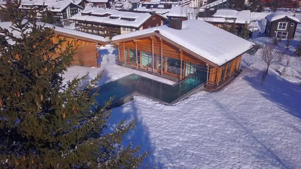 Aerial drone view of a woman swimming in a pool at a luxury spa resort