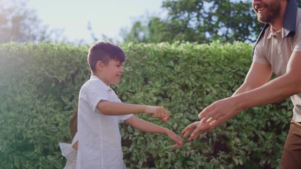 Parents with Children Playing Blind Man Buff. Man Eyes Tied with Blindfold