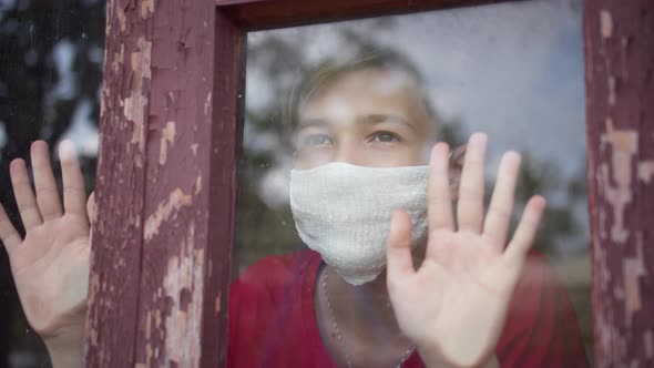 Boy in Mask Looks Outside in the Medical Mask, Covid 19