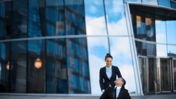 Invalid Businessman with Handsome Businesswoman Walking Near Businesscenter.