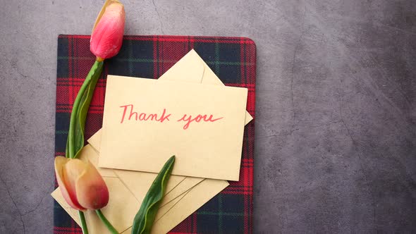 Thank you Message and Envelope on Wooden Table