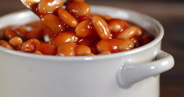 The Beans in the Tomato Sauce in the Bowl Slowly Rotate. Macro Background.