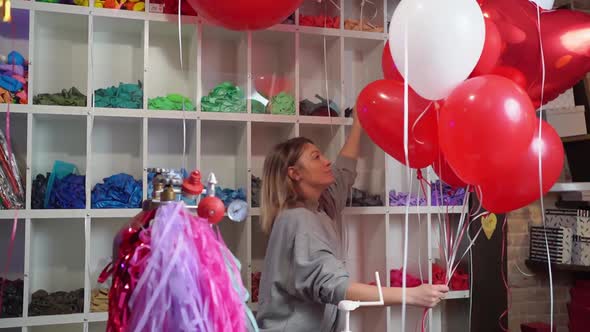 Woman Makes Composition of White Red Foil Balloons in Form of Heart and Ball