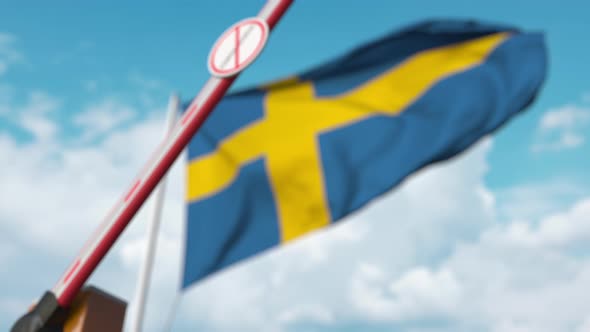 Closing Barrier with STOP CORONAVIRUS Sign at the Swedish Flag alt