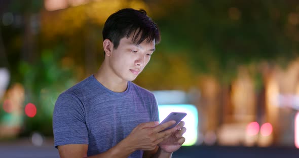 Man use of mobile phone in city at night