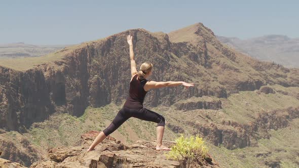 Back View of Woman Stretching on Rocks - Dolly Shot