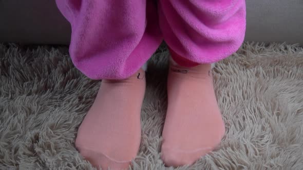 Young Woman Gets Out of Bed in Pink Pajamas in the Morning
