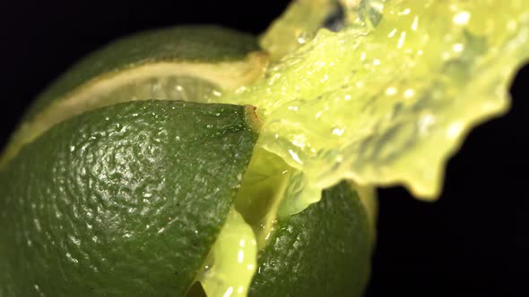 Fresh Lime Fruit Squirting with Juice in Slow Motion in Black Background