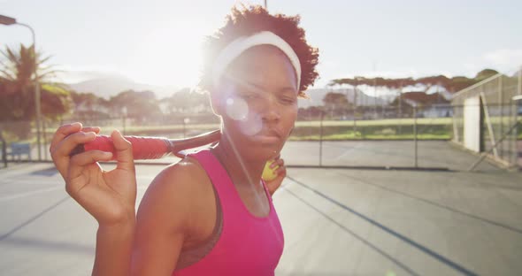 Video of african american female tennis player holding racket and looking at camera