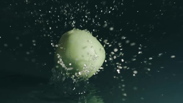 Green Apple Falls on Shallow Water Surface