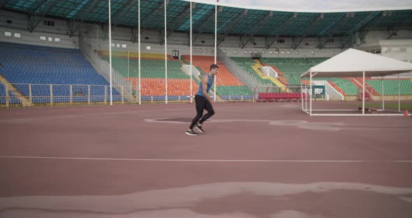 Sportsman Doing High Jump on Stadium