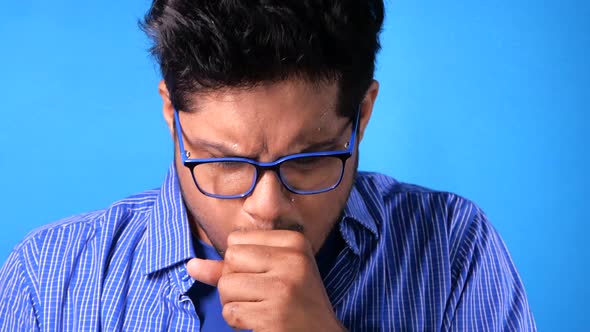  Young Man Coughing and Sneezes on Blue Background 