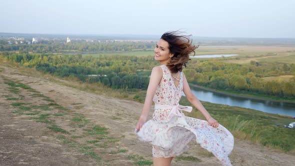 Joyful Barefoot Woman Runs Turning Around Along Riverbank