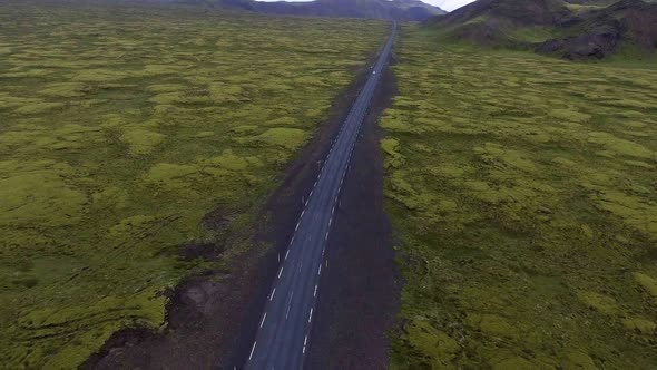 Aerial View of Road Through Mossy Lava Field in Iceland