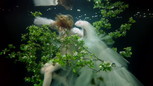 Stunning Young Woman is Floating in Fabulous Garden in Depth of Magical Ocean