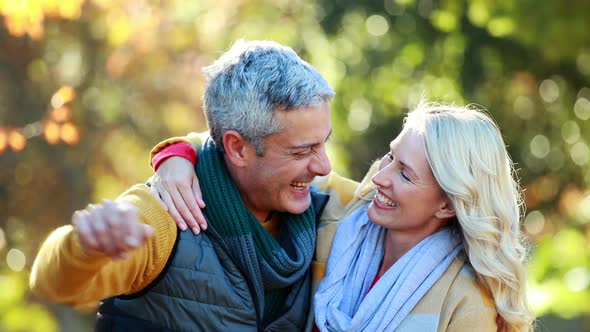 Couple hugging and pointing finger in park