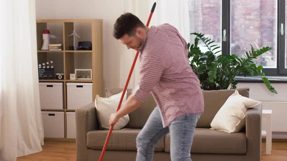 Man with Broom Cleaning and Having Fun at Home 32