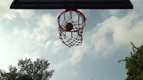 Orange Basketball Ball Goes Into Basket After Several Bounces Around