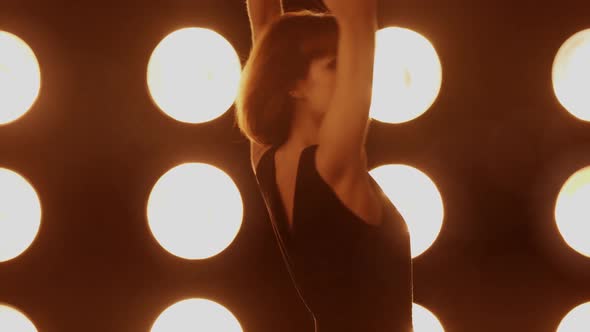 Beautiful woman dancing in front of a wall of lights