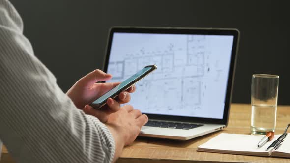 Man using smartphone and laptop