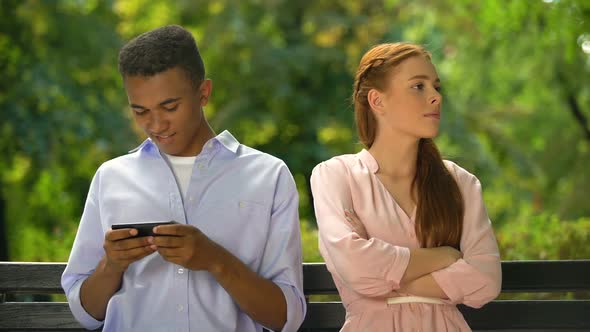 Mixed-Race Boy Ignoring Girlfriend Playing Games on Smartphone, Addiction