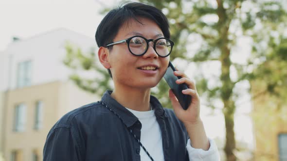 Young Asian Woman Having Phone Talk Outdoors
