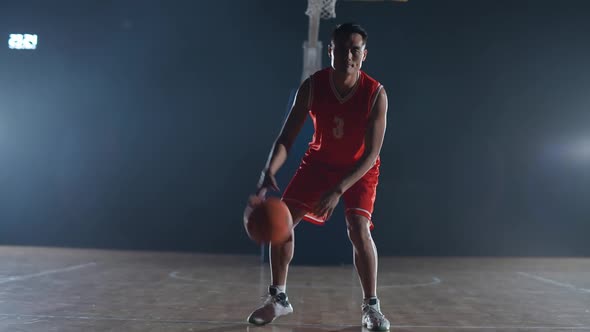 Basketball Player Hits the Ball on the Floor Warms Up Before the Game Asian Basketball Player Looks