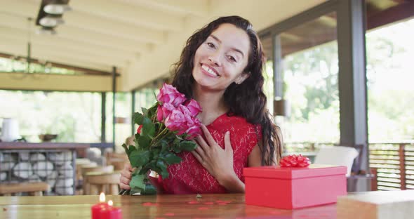 Happy biracial woman with roses making valentine's day video call, sending kisses