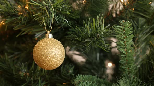 Glitering bauble hanged on the branch 4K 2160p 30fps UltraHD footage - Golden color ornament  on Chr